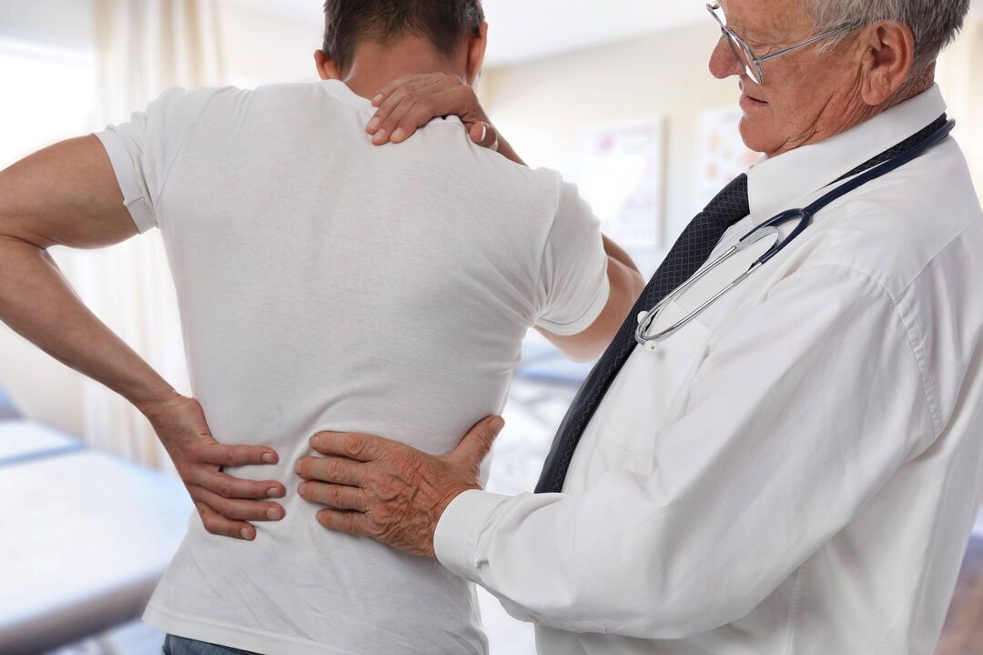 lekár vyšetrujúci pacienta s bolesťou chrbta